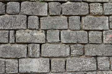 Photo texture of old and ancient gray colored stone wall.