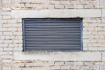 Photo texture of old ventilation metal hatch on brick wall.