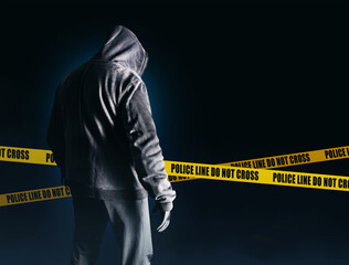 Photo of scary horror stranger stalker man in black hood and clothing on dark blue background with...