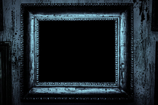 Scary horror haunted black picture frame on grunge dirty abandoned house wall.