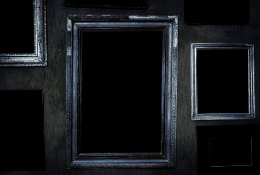 Scary horror haunted black picture frames on grunge dirty abandoned house wall.