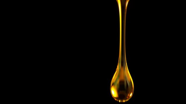 Super Slow Motion Shot of Falling Golden Droplets Isolated on Black Background at 1000 fps.