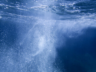 Bubbles under the sea in the azure clear blue sea water. Mediterranean sea bubbles. Real image very suitable for backgrounds, Air bubbles underwater rising to water surface, natural scene.