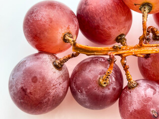 Red grapes berries on the white background. Bunch of grape.