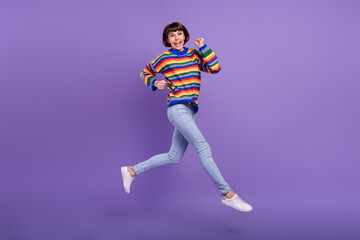 Fototapeta na wymiar Photo of fast active lady jump hurry run wear striped pullover jeans footwear isolated violet color background
