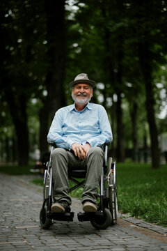 Adult disabled man in wheelchair holds paper sheet