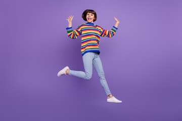 Obraz na płótnie Canvas Photo of glad cheerful lady jump move enjoy flight have fun wear sweater jeans shoes isolated purple color background