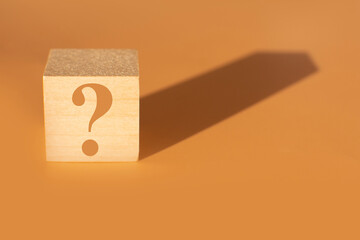 a question mark on a wooden cube. FAQ frequency asked questions, Answer and Brainstorming Concepts