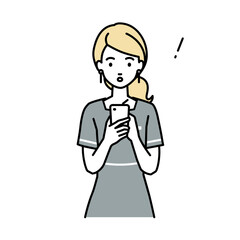 立ってスマートフォンを操作して何かに気づいて驚いたエステ店員の女性