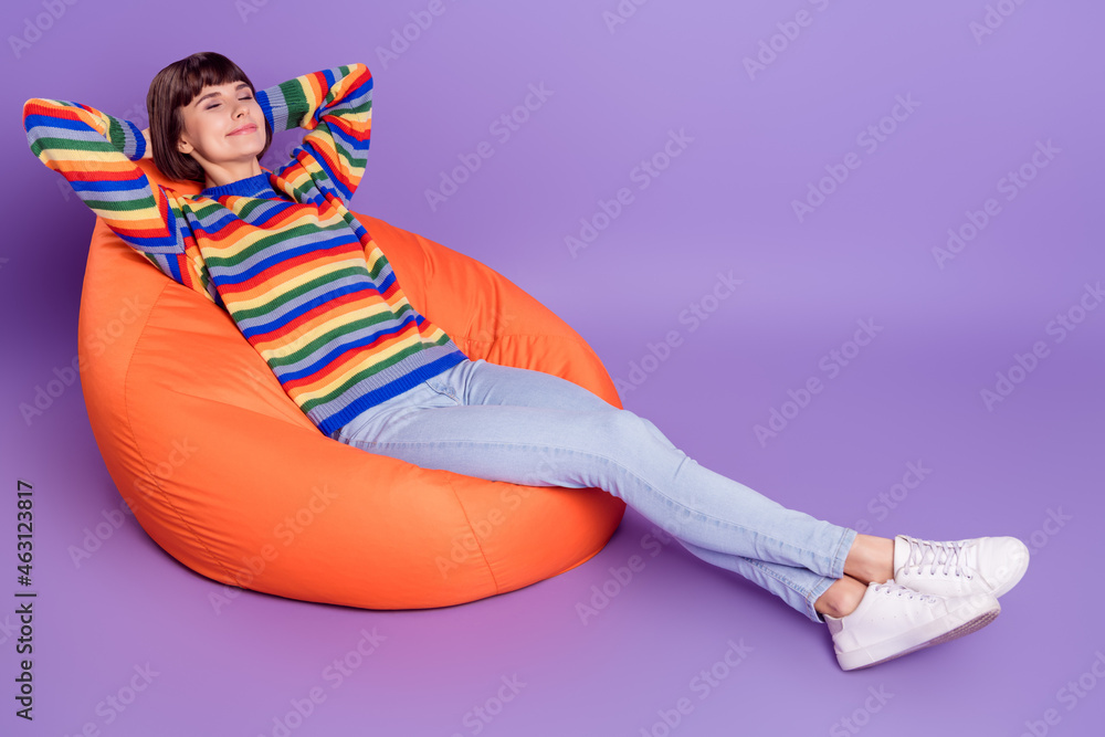 Poster Photo of positive inspired lady sit beanbag enjoy break nap wear striped sweater isolated violet color background