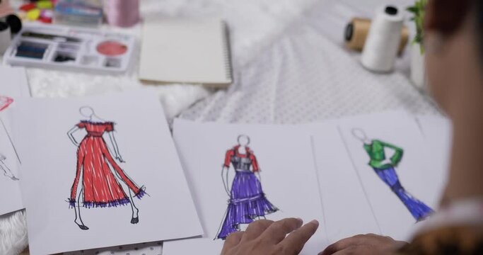 Close up hand of fashion designer man checking a sketch clothing paper