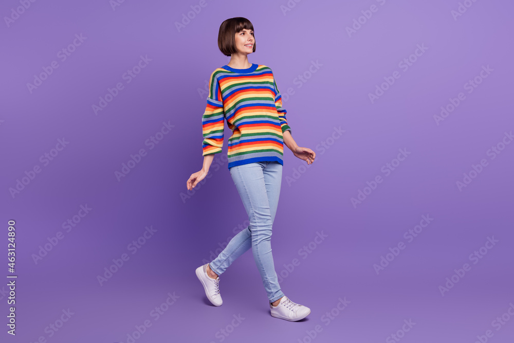 Wall mural Profile photo of positive pretty cute lady walk wear striped pullover jeans footwear isolated purple color background