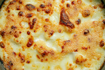 Oven baked brown cheese crust, kitchen background, close up , top view