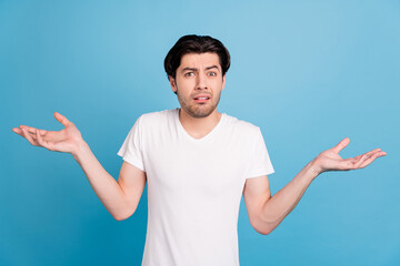 Photo of unsure troubled guy shrug shoulders confused face wear white t-shirt isolated blue color background