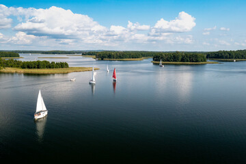 Aerial view of green islands and clouds at summer sunny day. Masurian Lake District in Poland. 