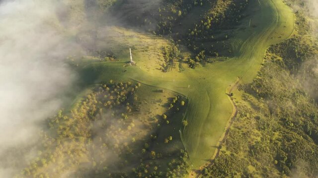Aerial view on amazing flowing morning fog spreads over green meadows in autumn mountains. Ukrainian Carpathian mountains. UHD 4k video