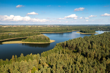 Aerial view of green islands and clouds at summer sunny day. Masurian Lake District in Poland. 