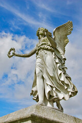 Fototapeta na wymiar Statue of angel against the blue sky in Enniskerry, Ireland