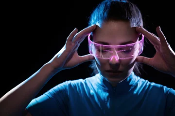 Poster Concept of future technology or entertainment system, virtual reality. Female portrait lit by HUD interface © konradbak