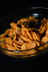 Cereal caramel cornflakes in a cup on black background