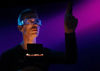 Rolgordijnen Man controlling a futuristic digital interface © konradbak