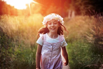Tuinposter Portrait of cute kid girl with bloom flowers. Nature outdoor. Child in nature concept. © konradbak