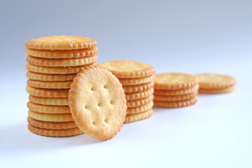 Crackers or biscuits arranged in vertical rows and one leaning against on white background.
