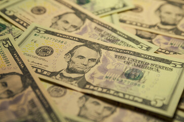 American currency. Five-dollar bills close-up. Selective focus.