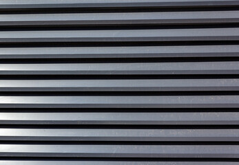 Corrugated sheet metal, badly painted with gray paint for background. Metal corrugated roofing sheet.Painting of metal surfaces for rust control Abstract background for sites and layouts. Iron fence