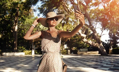 Poster Happy young woman with straw hat enjoying her summer holidays © konradbak