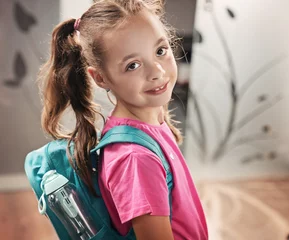 Fotobehang Happy schoolgirl with backpack smiling and looking at camera © konradbak