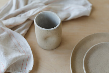 ceramic cup and plates on a wooden table top view. minimalist set of handmade ceramic tableware and pottery