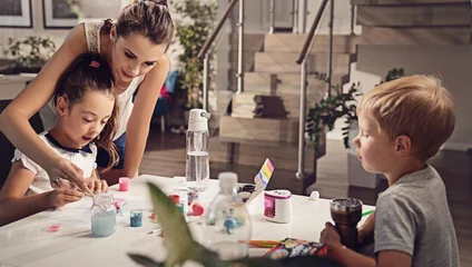Foto op Plexiglas anti-reflex Young mom and her kids having fun and painting at home © konradbak