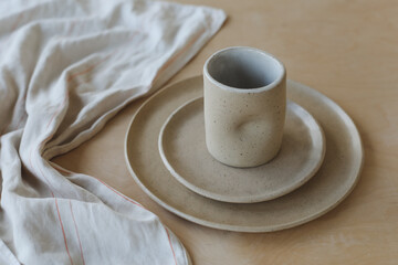 ceramic cup and plates on a wooden table top view. minimalist set of handmade ceramic tableware and pottery
