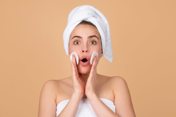 Excited beautiful woman with clean skin. Girl beauty face care. Facial treatment. Spa skin care, beauty woman wearing hair towel after beauty treatment. Beautiful perfect skin, isolated beige.