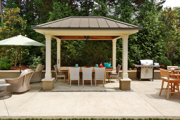 Outdoor garden patio scene with grill, table, chairs, and umbrella