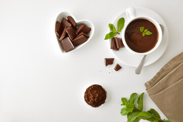 Hot chocolate in cup and pieces in a heart container