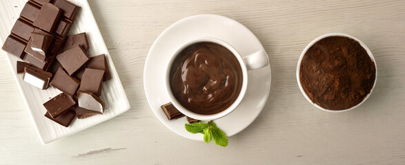 Hot chocolate powder and pieces on wooden table top background