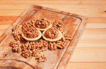 Cakes with walnuts and caramel and walnuts near on cutting board. Selective focus.