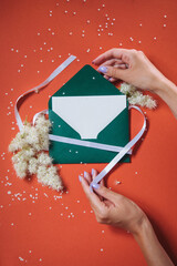 green envelope in hands on an orange background