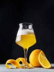 Glass of citrus beer on dark background