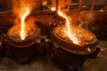 A jet of molten steel is poured into ladles. Metallurgical industry