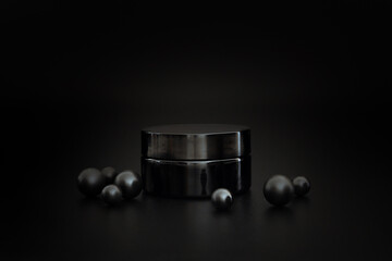 Black unbranded cosmetic cream jar. Cream presentation on the black background. Elegant mockup....