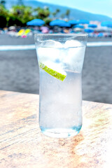 Glass with very cold soda, ice and lemon on the beach. Tenerife. Canary Islands.