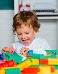 Happy launching toddler playing with building blocks toys at kindergarten. Elementary school and...