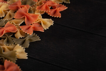 Dry farfalle tricolore pasta pattern. Uncooked Macaroni. Heap of raw traditional italian pasta on a...