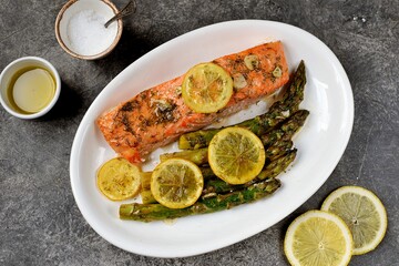 Baked salmon fillet with asparagus, lemon and olive oil. Healthy eating.