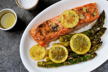 Baked salmon fillet with asparagus, lemon and olive oil. Healthy eating.