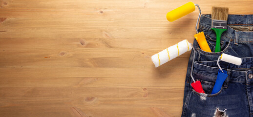 Kit of tool in jeans pocket at wooden table background. House renovation concept
