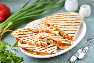 Mexican tortilla with chicken fillet,  bell peppers, onions and beans in tomato sauce.